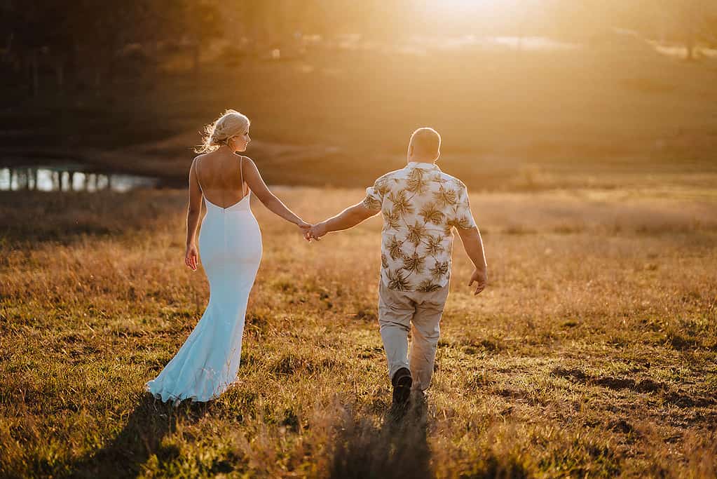 Wedding couple walking away with lens flare