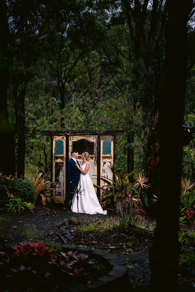 Bride & groom in front of doorway at Granite Ridge Gardens
